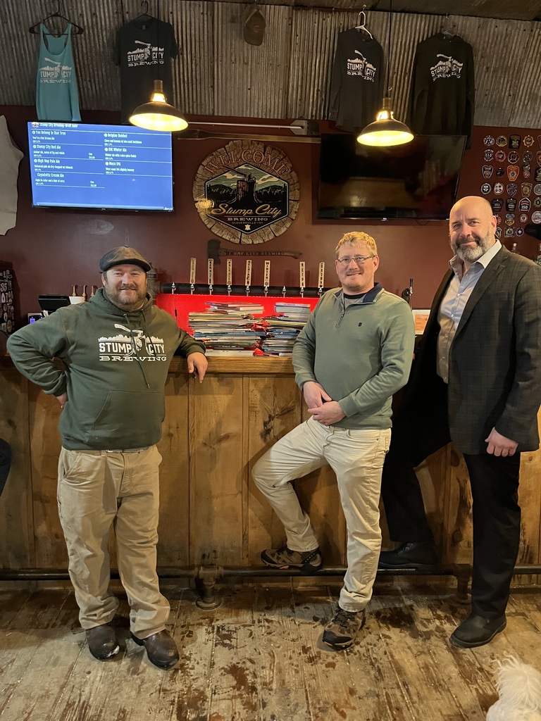 Stump City Brewery Co-owners Nick and Matt Sherman stand with GESD Superintendent, David Halloran, near a small portion of the books that have been collected to support GESD's Talking is Teaching Little Free Libraries. Donations to support the effort will continue at Stump City until the end of the month.  